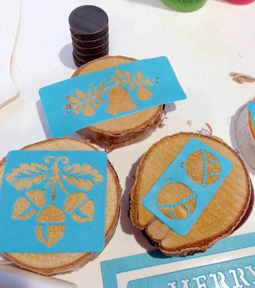 Adhesive stencils attached to wood slices