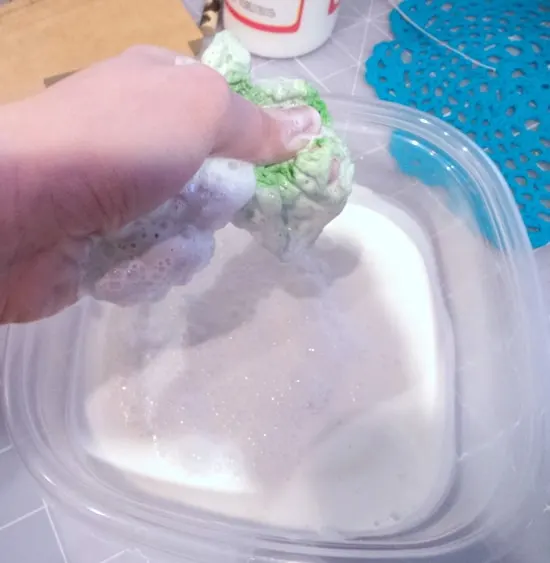 Squeezing a doily out into a plastic container