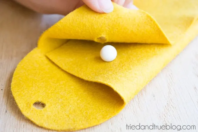 Folding the felt pencil pouch together and buttoning