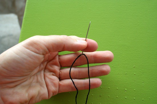 Black thread on an embroidery needle