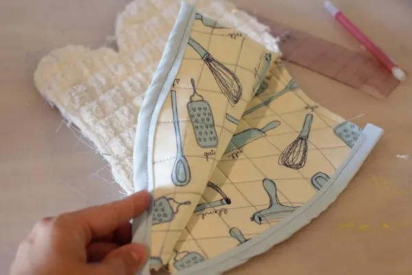 Sew bias tape onto the bottom of the two quilted fabric pieces