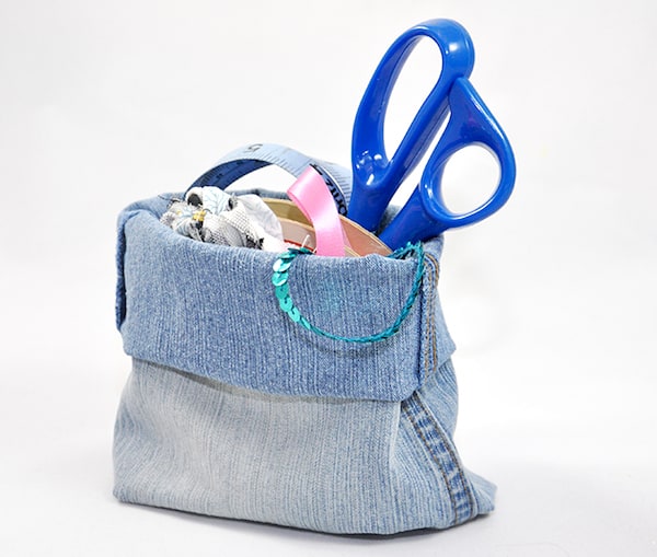 Recycled denim storage bin with sewing supplies inside