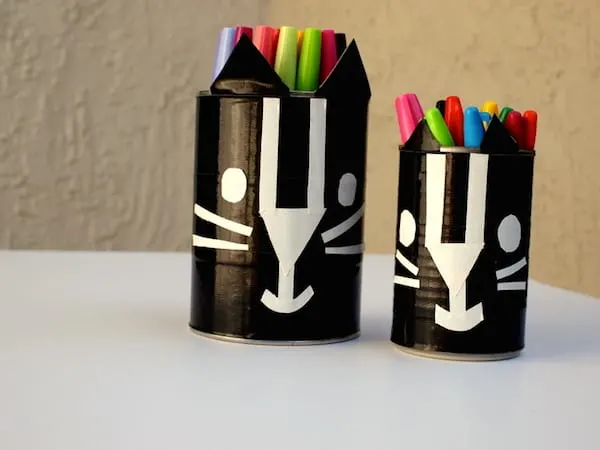 Learn how to make these black cat containers with duct tape - kids will love this Halloween craft!