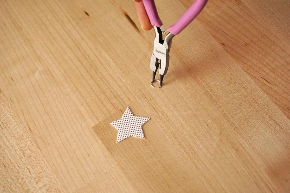 Plastic canvas star and an open jump ring with pliers