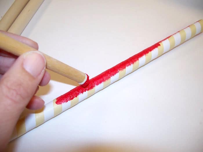 Painting a dowel rod wrapped with masking tape using a dauber