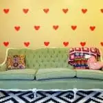 DIY temporary wall decals with a green couch and a black and white rug