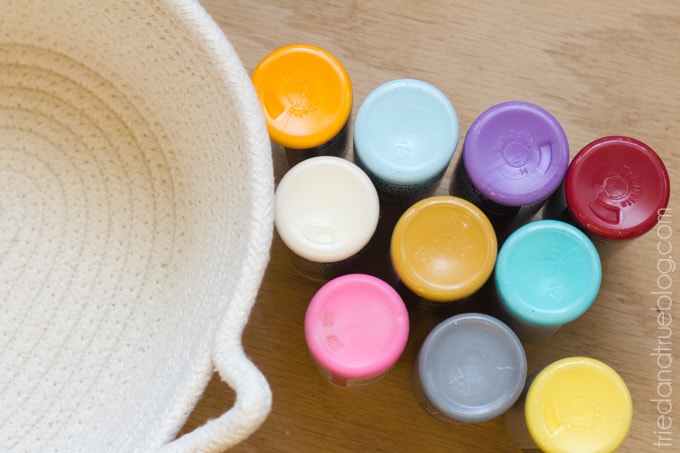 Bottoms of ten paint bottles of various acrylic paint colors