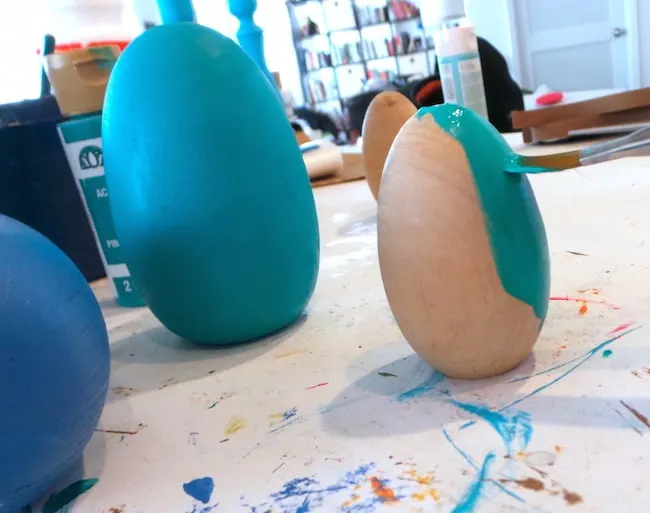 Painting a wood Easter egg with aqua acrylic paint