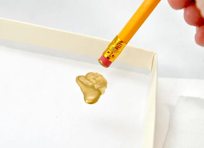 Dipping a pencil eraser into gold metallic paint