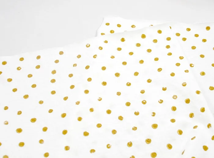 Gold dots painted on t-shirt material