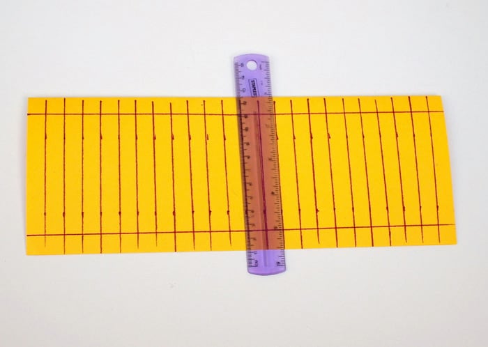 Lines drawn vertically on the yellow construction paper