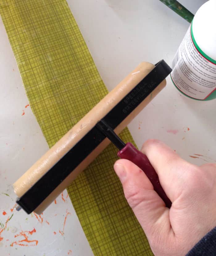 Using a brayer to smooth down the fabric