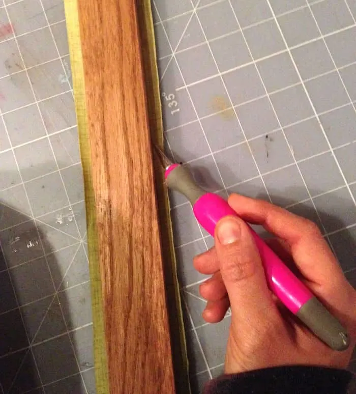 Trimming the fabric from the wood with a craft knife