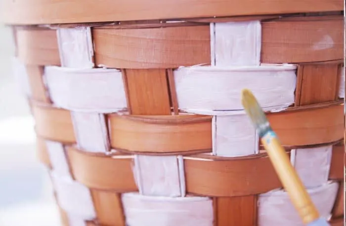 Painting with white acrylic paint on the weave of a basket