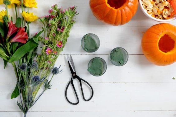 Floral foam in glass votives with a pair of scissors and bouquet of flowers