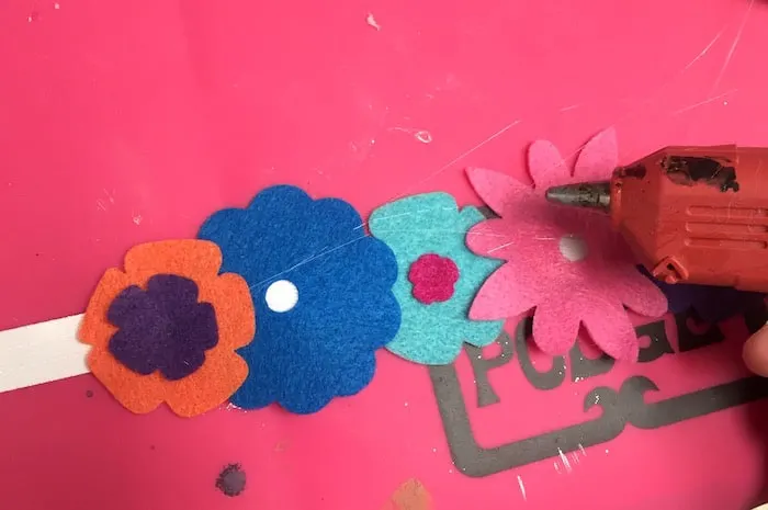 Making a headband with hot glue, ribbon, and felt flowers