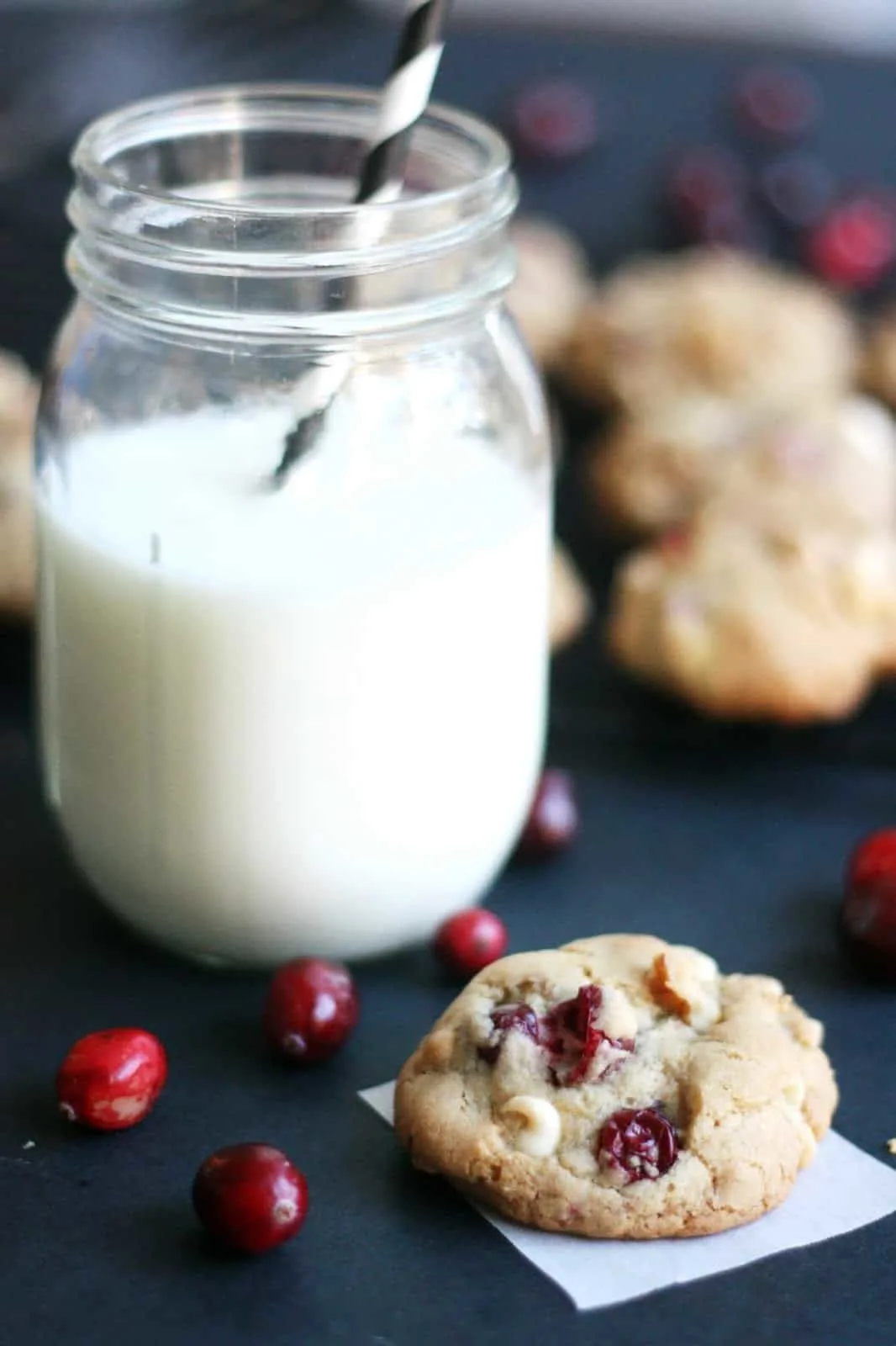 white chocolate cranberry cookie with a glass of milk