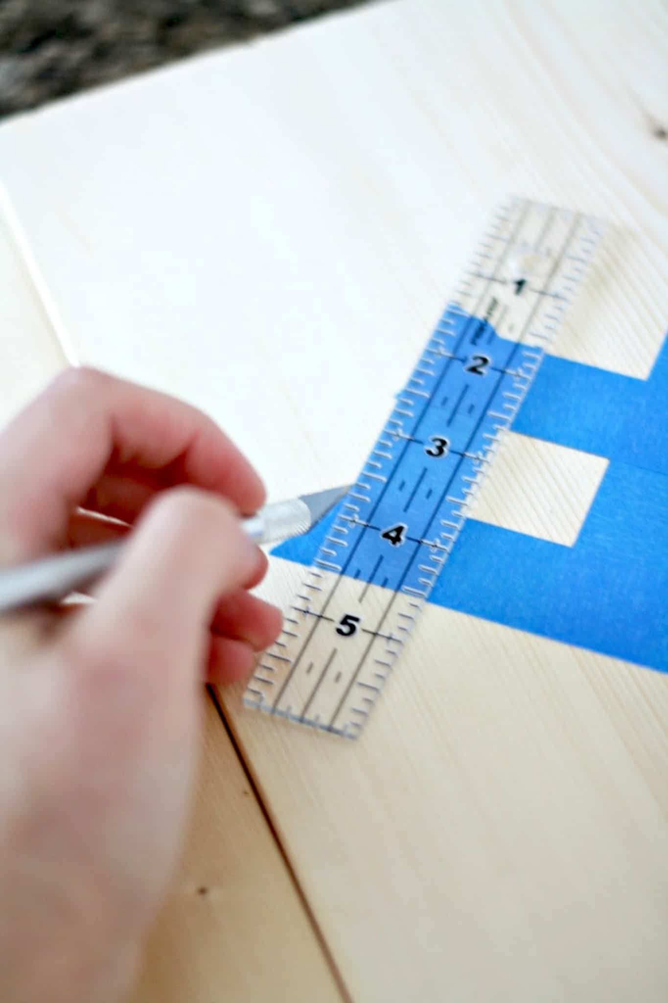 Cutting painter's tape using a ruler and craft knife