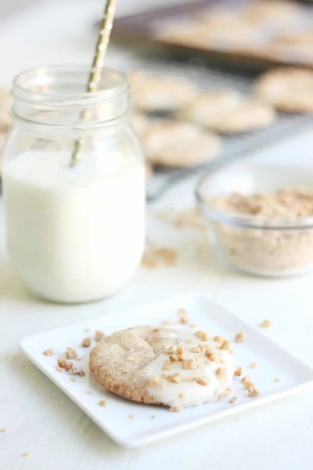 White chocolate snickerdoodle on a white plate in front of a mason jar filled with milk