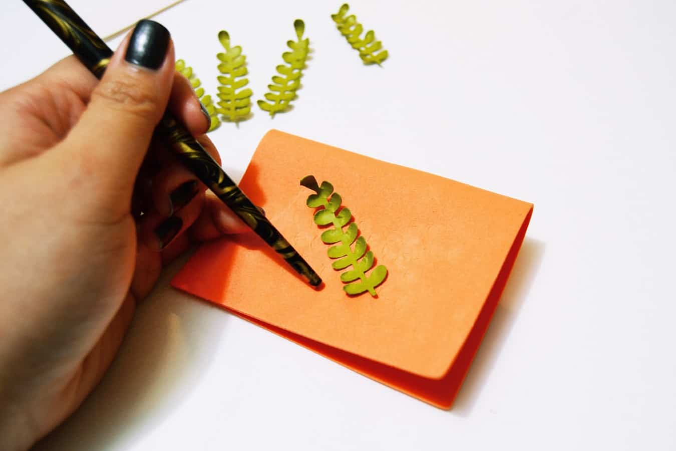 using the tip of a calligraphy pen to burnish the leaves