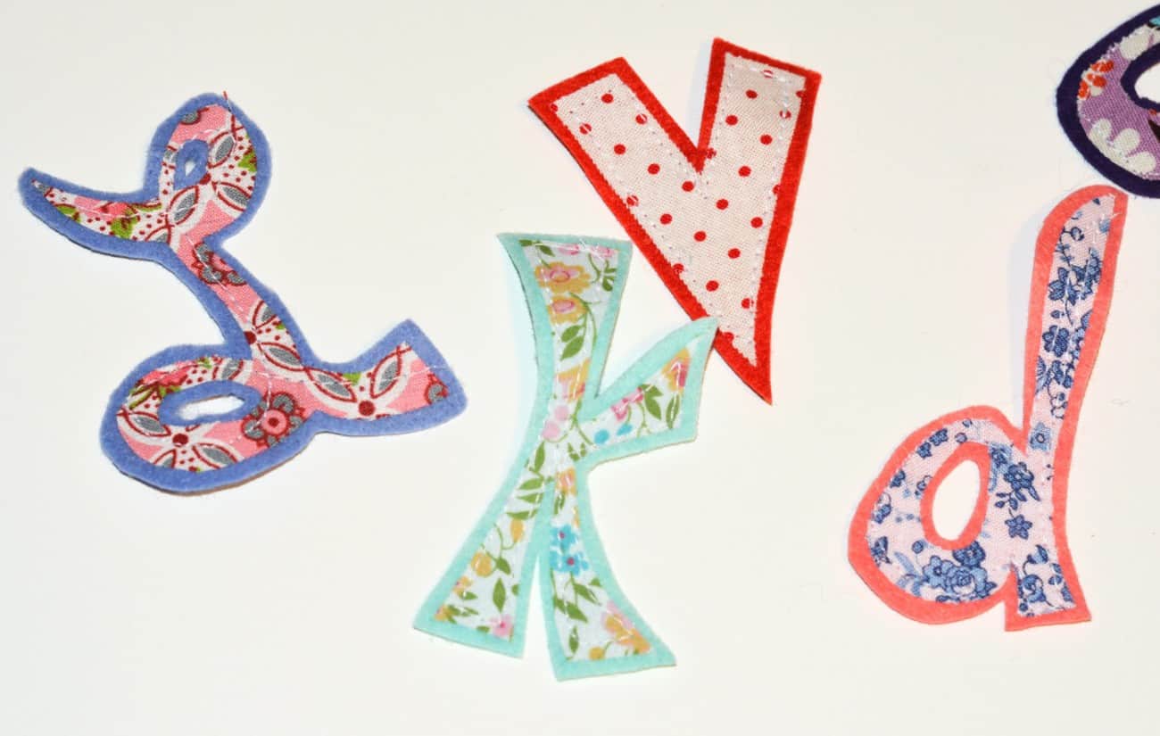 Fabric stitched onto felt using sewing machine creating letters