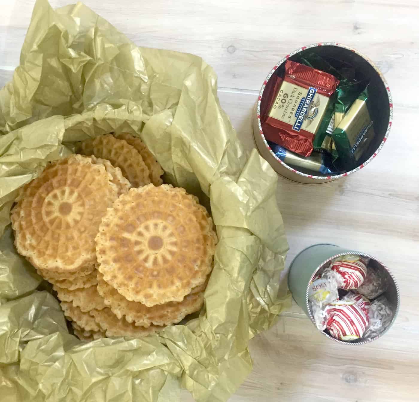 Metal Christmas cookie containers filled with candy and cookies