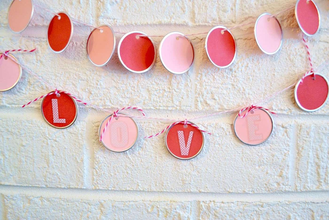 Use metal rimmed tags from the craft store to make a pretty DIY garland in minutes! Perfect for Valentine's Day or any other holiday - no skills required.