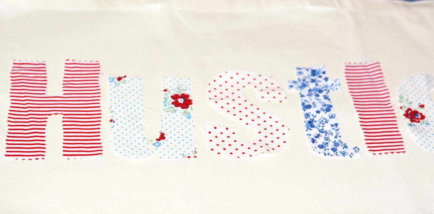 Fabric letters laid out on the front of a tote