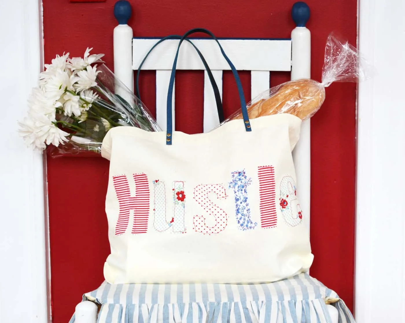 DIY tote with an applique word sitting in a chair