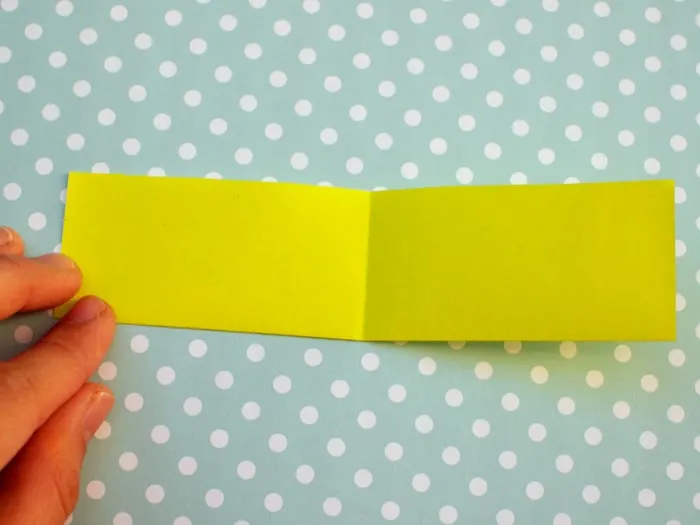 Opened up piece of origami paper with a fold in the middle