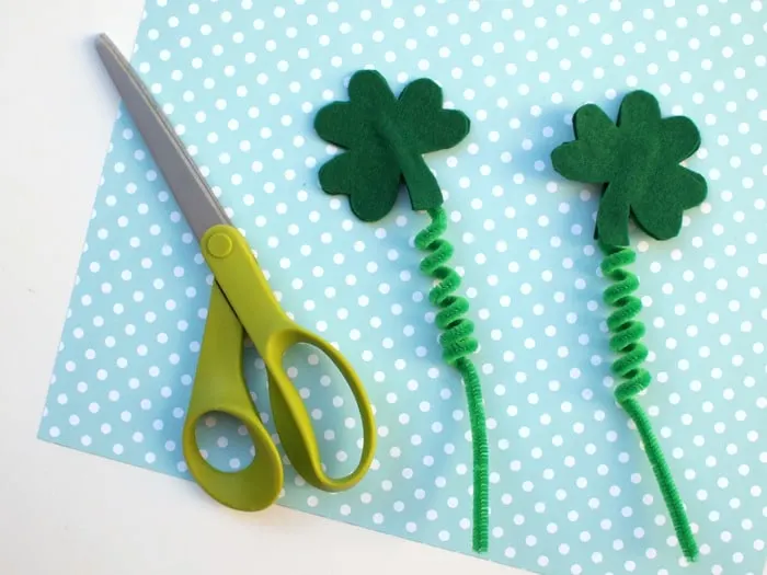 Pair of scissors and two shamrock boppers sitting next to them