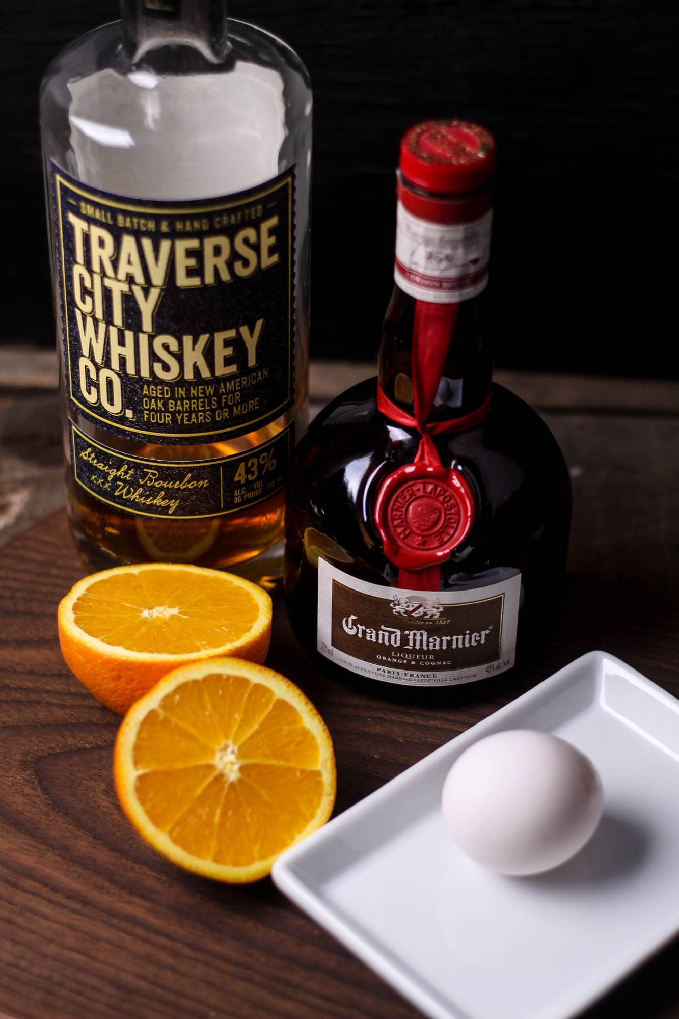 Traverse City Whiskey, Grand Marnier Liqueur, a sliced orange, and an egg