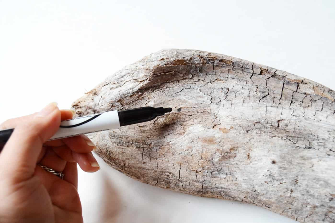 Marking holes on driftwood with a Sharpie