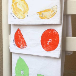 Fruit stamps on tea towels in yellow, orange, and mint