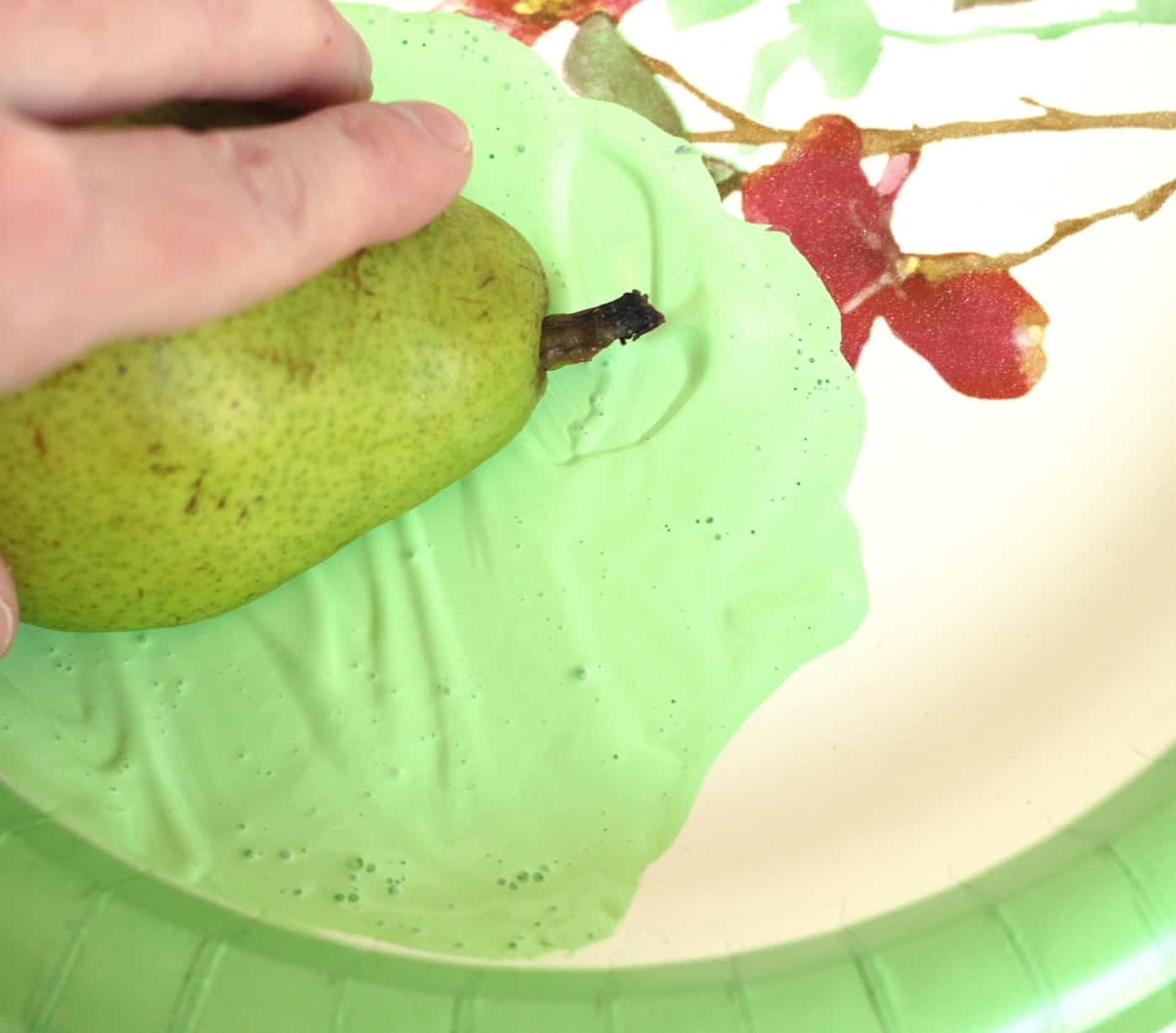 Pear fruit stamp placed into paint