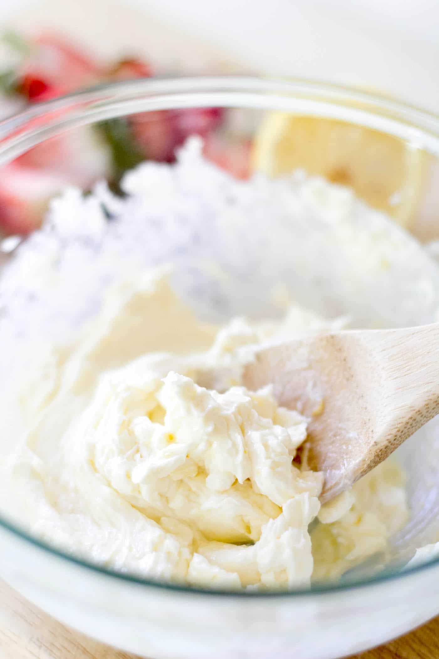 Mixing together cream cheese, sugar, lemon juice, zest, and vanilla in a bowl