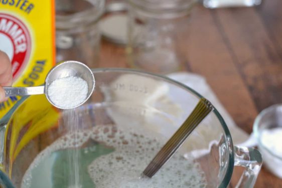 Borax being added to a container of hot water and castile soap