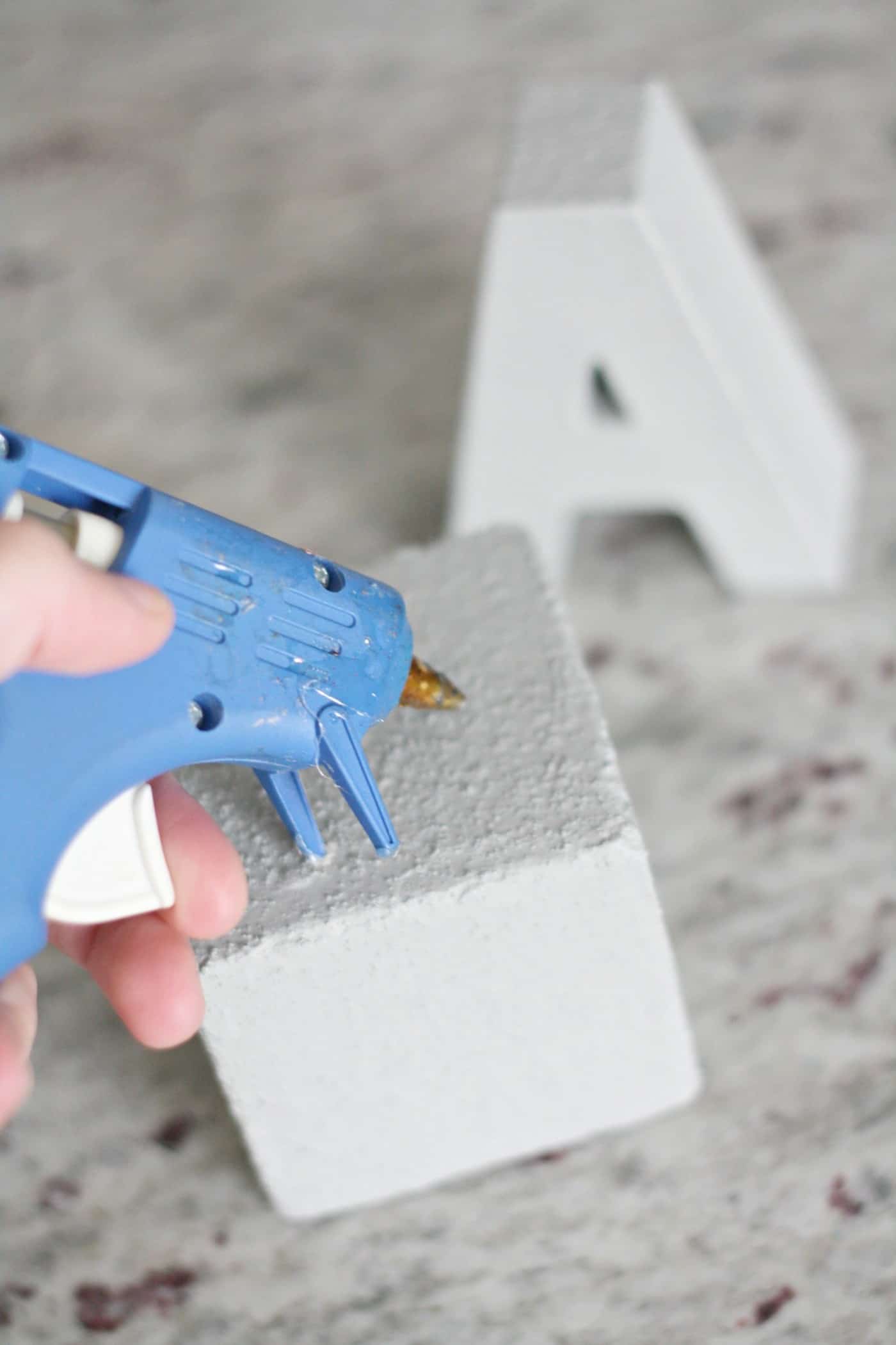 Gluing the letter to the cube using a hot glue gun