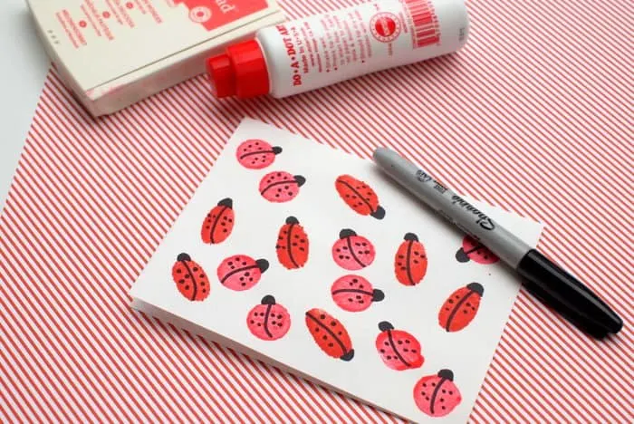 Ladybug heads and dots drawn onto the red fingerprints with Sharpie