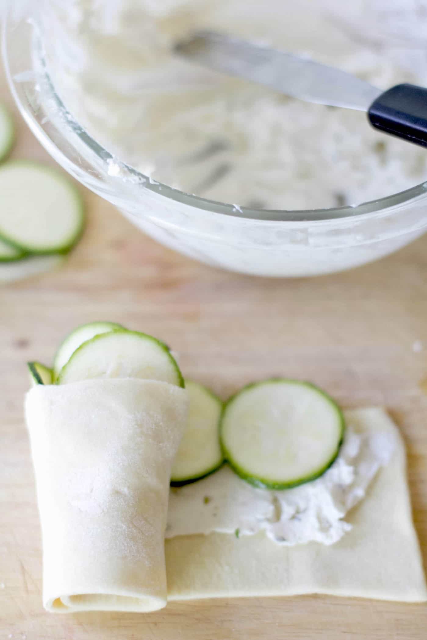rolling up the puff pastry dough with the cheese and zucchini