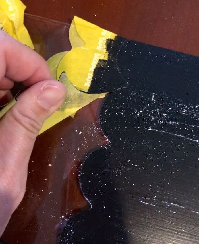 Peeling scalloped tape off of the glass