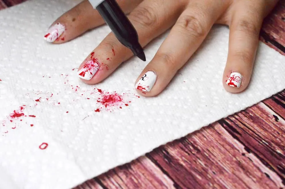 Drawing RIP on splattered nails with a Sharpie