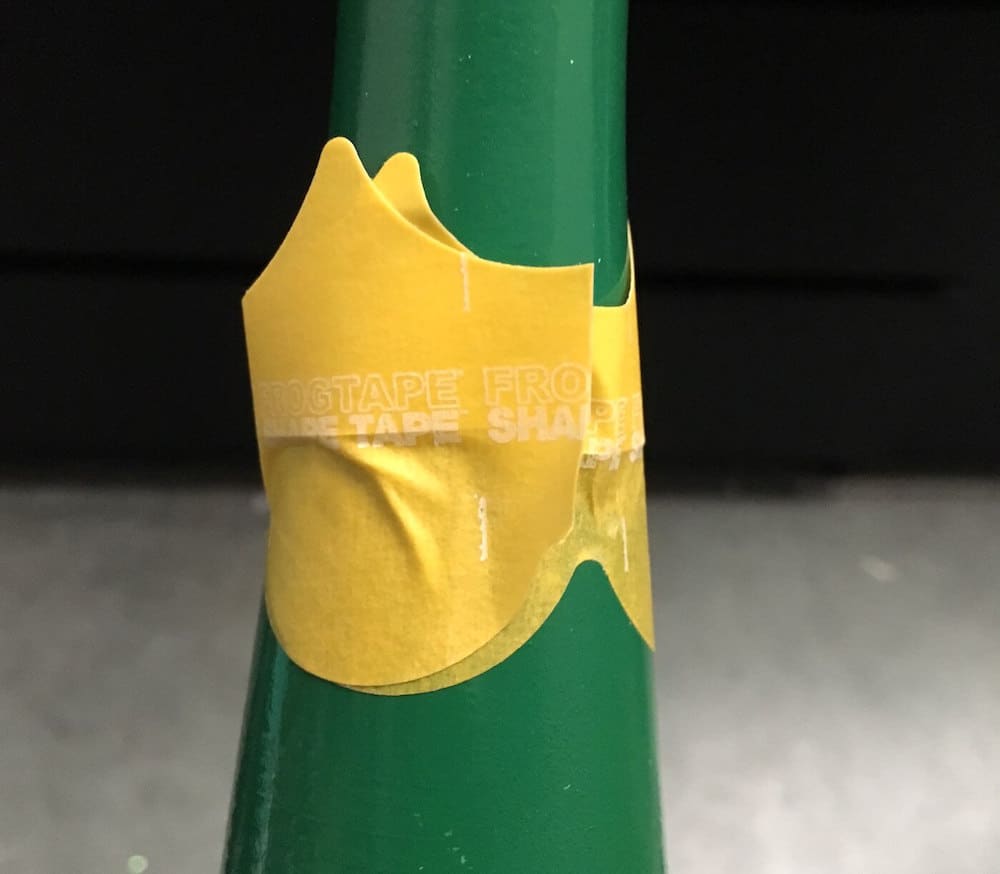 Scalloped stencil tape at the top of a bottle neck