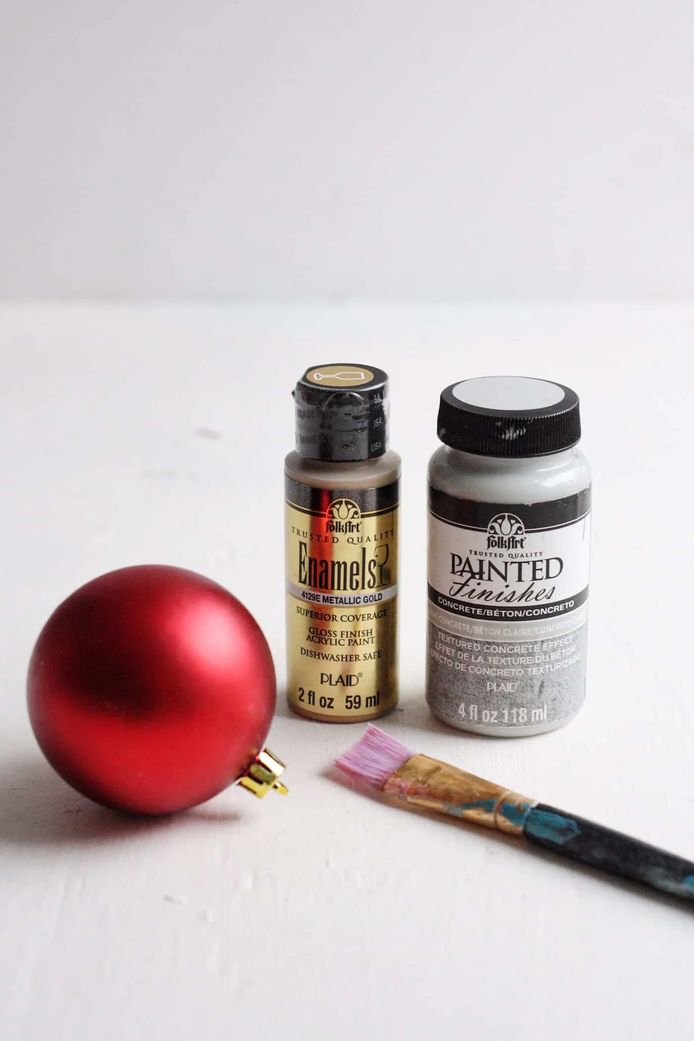Red Christmas ball ornament, Enamel gold paint, and concrete painted finish with a paint brush
