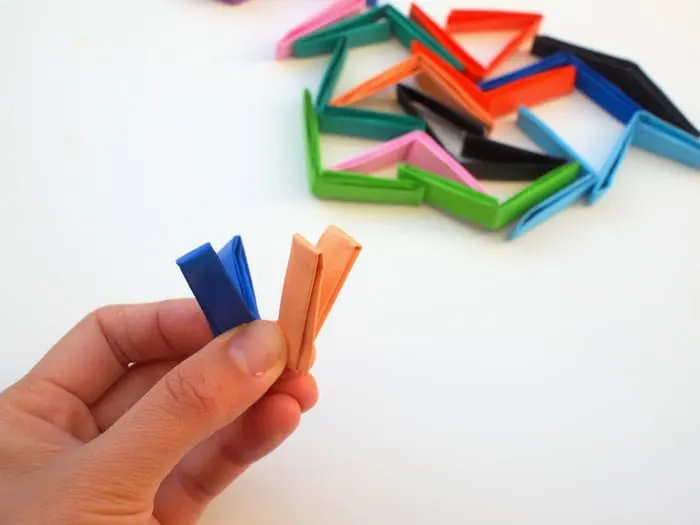 Folding colorful origami paper pieces