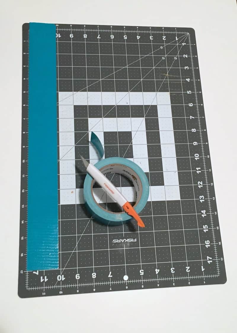 Craft mat with aqua Duck Tape and a craft knife