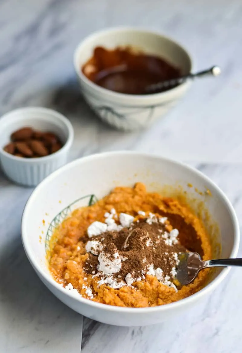 Pumpkin puree in a bowl with spices, coconut butter, and coconut oil