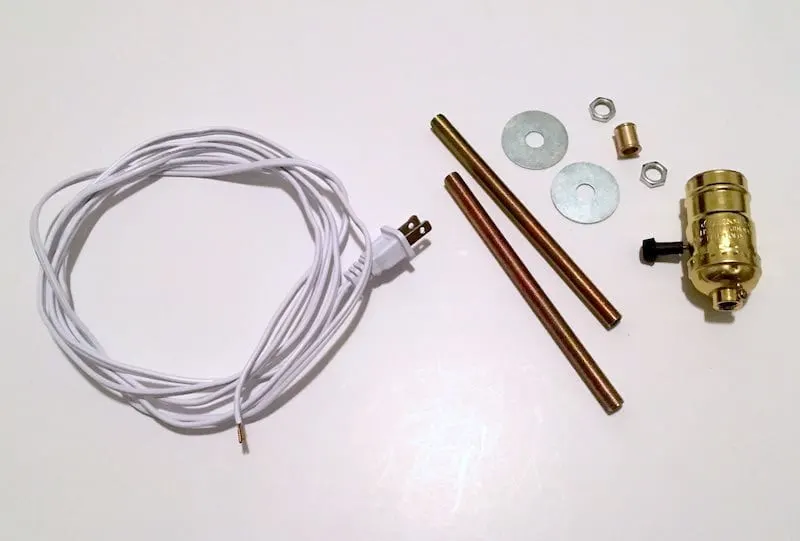 Supplies to make a lamp including a cord, brass pipe, fittings, and washers