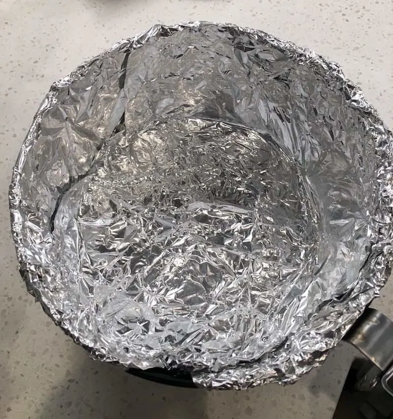 Air fryer tray wrapped in aluminum foil