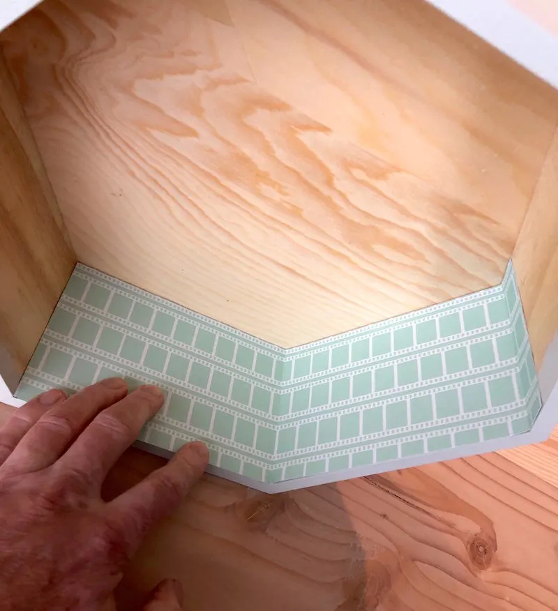 Paper placed inside the shelf before spraying with adhesive